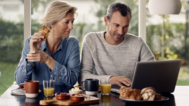 Nordea direct_Couple-home-smiling-eating-with-laptop-small